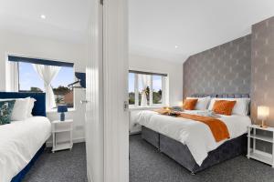 a bedroom with two beds and two windows at Modern House, Pool Table, Parking & Garden in Fallings Park