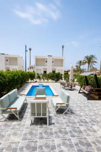 a patio with chairs and a swimming pool at Porto Matrouh Elabd Family in Marsa Matruh