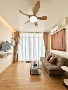 a living room with a couch and a ceiling fan at Rimna Pool Villa in Hat Yai