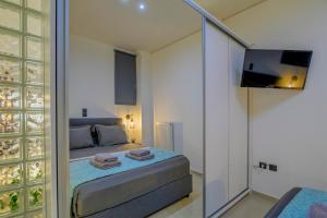 a small bedroom with a bed and a television at Kalafatis Downtown Apartment in Itea