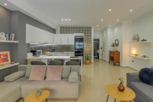 a living room with a couch and a kitchen at Kalafatis Downtown Apartment in Itea