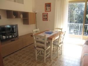 a kitchen with a table and chairs and a television at Appartamento Island Brioni in Grado-Pineta