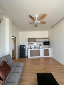 a living room with a couch and a ceiling fan at Rimna Pool Villa in Hat Yai