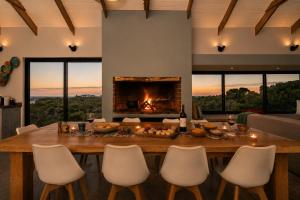 a dining room with a table and a fireplace at Cast Away at Romansbaai - Salted Fynbos Staying in Gansbaai