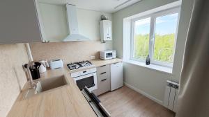 a kitchen with a stove and a sink and a window at Vanilla Sunrise Apartments in Sillamäe +3 photos