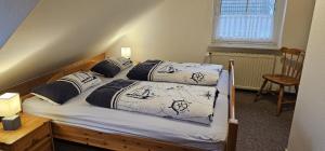 a bedroom with two beds and a table and a chair at Medemstern I in Otterndorf