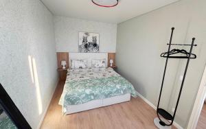 a bedroom with a bed with a green and white comforter at Vanilla Sunrise Apartments in Sillamäe