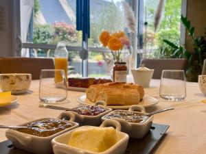 a table with bread and other food on it at Chambre calme avec petit déjeuner in Gévezé