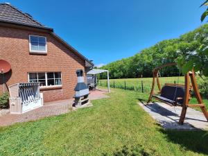 a yard with a playground and a house at Medemstern II in Otterndorf