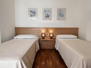 two beds sitting next to each other in a room at Mareluce in Letojanni