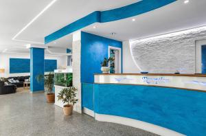 an office lobby with blue walls and a reception counter at Hotel Blu Eden - Calabria oltre il mare in Praia a Mare +46 photos