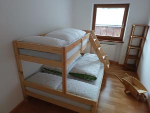 a bunk bed in a room with a window at greenlodge pornplatthof in Auna di Sopra