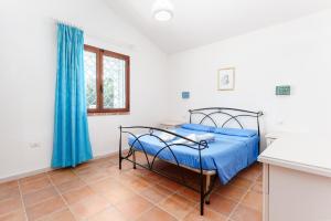 a bedroom with a bed with blue sheets and a window at Sole in Onifai +35 photos