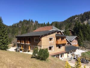 a large wooden house on a hill with trees at La Mainaz Hôtel Restaurant Genève - Gex - Mijoux in Gex