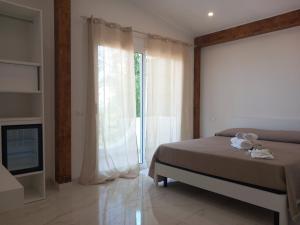 a bedroom with a bed and a large window at Appartamenti Tropea Gargano in Parghelia