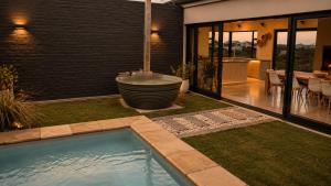 a backyard with a bath tub and a table with chairs at Cast Away at Romansbaai - Salted Fynbos Staying in Gansbaai