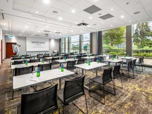 a classroom with tables and chairs in a room with windows at Hotel Mercure Poznań Centrum in Poznań