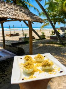 a plate of food with eggs on a beach at O'Sole Mio Assinie in Assinie
