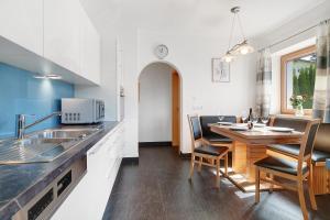 a kitchen and dining room with a table and chairs at Villa Reny in Meltina +28 photos