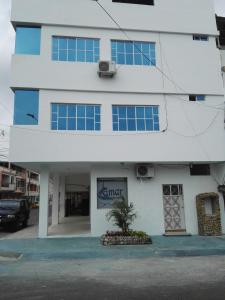 a white building with a tree in front of it at Francisco Habitaciones in Manta