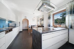 a kitchen with white cabinets and a large counter top at Villa Reny in Meltina