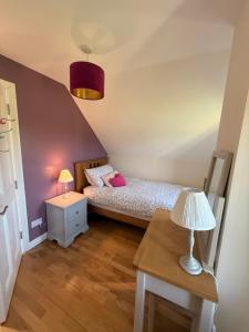 a bedroom with a bed and a table with a lamp at Peaceful Red Deer Cosy Apt in Letterfrack near The Connemara National Park in Letterfrack