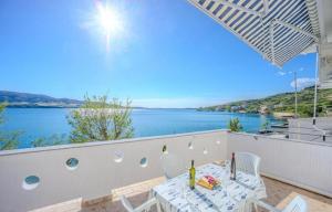 a table and chairs on a balcony with a view of the water at Apartments by the sea Metajna, Pag - 6289 in Zubovići