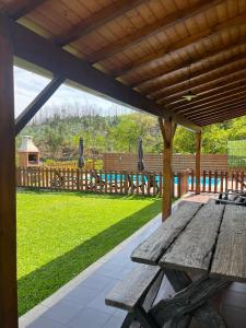 a wooden picnic table under a wooden pergola at Casa do Canastro in Sever do Vouga