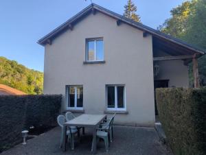 a table and chairs in front of a house at De l'onde au vert in Vivey