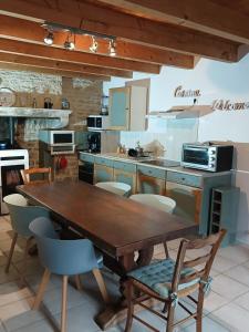 a kitchen with a wooden table and chairs at De l'onde au vert in Vivey