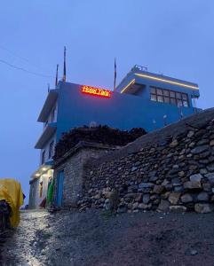 a building with a red sign on the side of it at Hotel Tara in Kāgbeni +1 photo
