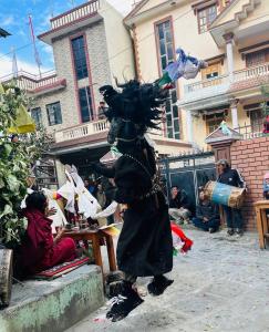 a person dressed in black standing in the street at Hotel Tara in Kāgbeni