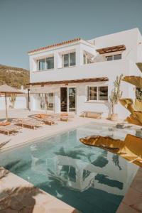 a villa with a swimming pool in front of a house at Casa Stellar - boutique villa with private pool and sea view - sustainably solar powered in Sant Josep de sa Talaia