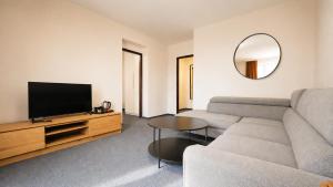 ein Wohnzimmer mit Sofa und Flachbildfernseher in der Unterkunft HLBOKÉ Hotel & Lesopark in Bojnice