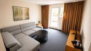 ein Wohnzimmer mit Sofa und Tisch in der Unterkunft HLBOKÉ Hotel & Lesopark in Bojnice