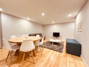 a dining room with a table and chairs and a couch at Torrinha's Backyard in Porto