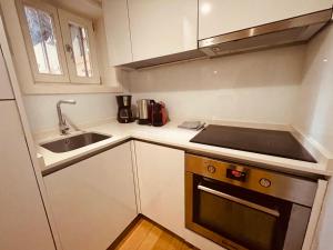 a small kitchen with a sink and a stove at Torrinha's Backyard in Porto