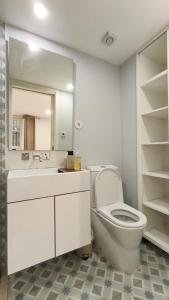 a bathroom with a toilet and a sink and a mirror at Torrinha's Backyard in Porto