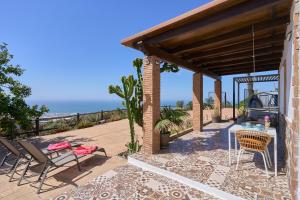 a patio with chairs and a table with the ocean in the background at Villa Javier in Torrox