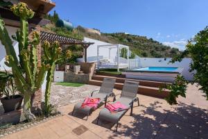 a patio with two chairs and a swimming pool at Villa Javier in Torrox