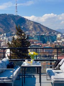 a balcony with a table and a view of a city at Bricks Hotel in Tbilisi City