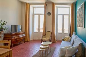 a living room with a couch and a table at Abri du vent, chambres et appartements in Fitou