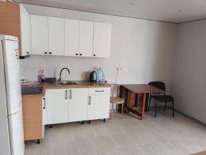 a kitchen with white cabinets and a wooden table at Центр,Апартаменти на Байди Вишневецького,97 in Cherkasy