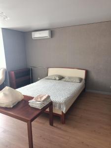 a bedroom with a bed and a wooden table at Центр,Апартаменти на Байди Вишневецького,97 in Cherkasy