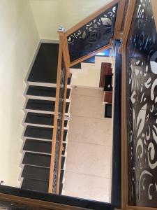 a spiral staircase with black and white railing at Cozi Rooms in Varkala