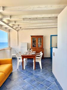 a dining room with a table and chairs and the ocean at Vivi Marettimo in Marettimo +21 photos