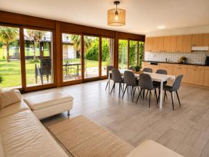 a kitchen and living room with a table and chairs at La maison IDEL in Yvonand