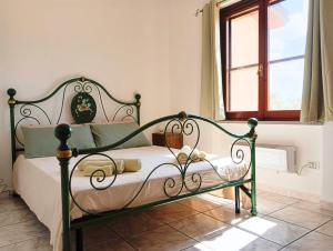a bedroom with a bed with a green frame at Casa Misè in Poggio Dei Pini