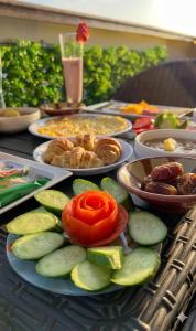 a table topped with plates of food and vegetables at Royal Plaza Pyramids View in Cairo