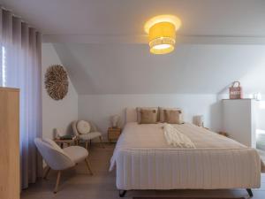 a bedroom with a large bed and two chairs at Maison Idyllique in Bree